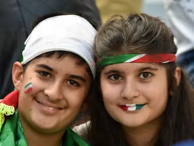 Sepasang suporter cilik "Team Melli" dengan setia menanti laga penyisihan Piala Dunia 2014 antara Iran kontra Nigeria, (16/6/2014). (AFP PHOTO/Luis Acosta)