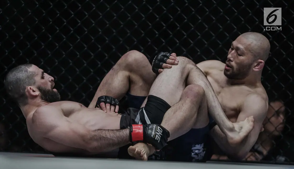Petarung Rusia, Yusup Saadulaev (kiri) dan petarung Jepang, Masakazu Imanari saling mengunci saat berlaga pada One Championship di Jakarta Convention Center (JCC), Sabtu (20/1). Pertarungan dimenangkan oleh Yusup Saadulaev. (Liputan6.com/Faizal Fanani)