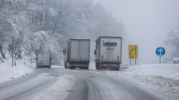 Truk melaju di jalan yang tertutup salju di Kocevje, dekat Ljubljana Slovenia, Senin (23/1/2023). Badai salju dengan angin kencang telah menghambat lalu lintas di jalan raya utama di Slovenia pada hari Senin dan menyebabkan beberapa bagian negara tanpa listrik untuk sementara waktu. (AP Photo)