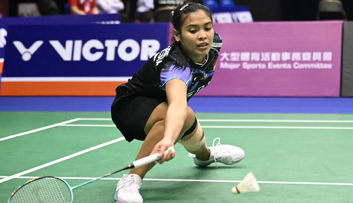 Tunggal putri Indonesia, Gregoria Mariska Tunjung, berusaha mengembalikan kok saat melawan wakil Spanyol, Carolina Marin, pada laga perempat final turnamen Hong Kong Terbuka 2023 di Coliseum, Hong Kong, Jumat (15/9/2023). Gregoria menang dua set langsung dengan skor 21-9 dan 21-18. (AFP/Peter Parks)
