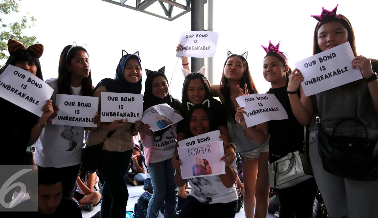 Para penggemar Ariana Grande memperlihatkan kertas bertuliskan ‘Our Bond is Unbreakable’ saat menunggu konser Ariana Grande bertajuk ‘The Honeymoon Tour ‘ di JIExpo Kemayoran Hall B-C, Jakarta, Rabu (26/8/2015). (Liputan6.com/Faisal R Syam)