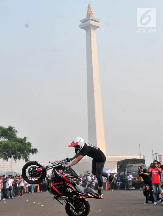 Freestyler melakukan atraksi freestyle sepeda motor saat memeriahkan Festival Damai Millenial Road Safety di Monas, Jakarta, Minggu (23/6/2019). Festival ini juga dimeriahkan oleh berbagai atraksi dan pertunjukan musik artis Tanah Air. (merdeka.com/Iqbal Nugroho)