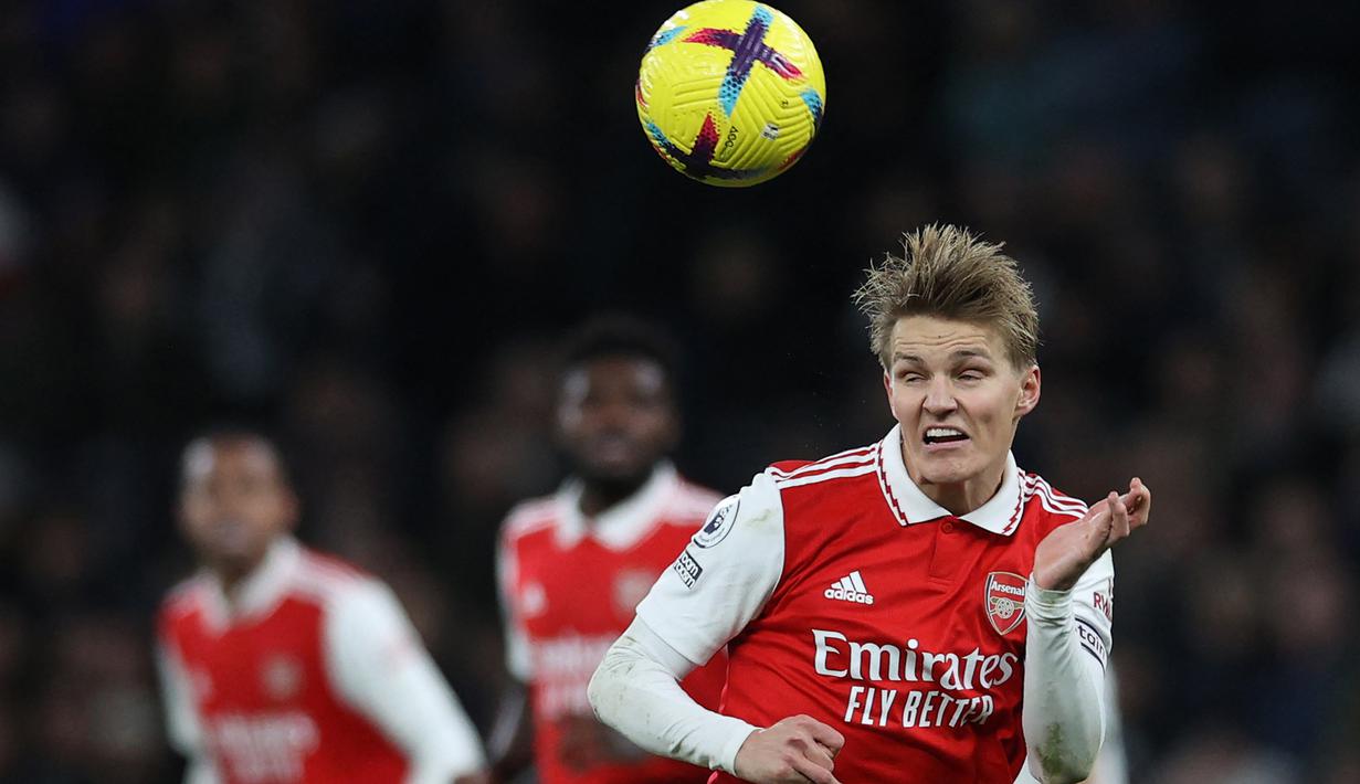 Martin Odegaard. Gelandang serang Arsenal, Martin Odegaard menyundul bola saat menghadapi Tottenham Hotspur dalam laga pekan ke-20 Liga Inggris 2022/2023 di Tottenham Hotspur Stadium (15/1/2023). Hingga kini ia telah mencetak 8 gol dan 5 assist dari total 17 laga di Liga Inggris. Arsenal pun tak tergoyahkan posisinya di puncak klasemen sementara berselisih 8 poin dengan Manchester City di peringkat kedua. (AFP/Adrian Dennis)