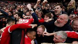Suporter Manchester United menyambut Anthony Martial setelah mencetak gol kemenangan ke gawang Everton pada semifinal Piala FA di Stadion Wembley, London, Sabtu (23/4/2016). (AFP/Adrian Dennis)
