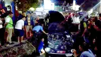 Kepolisian yang dibantu warga saat mengevakuasi mobil dinas milik pemerintah Gorontalo (Arfandi/Liputan6.com)