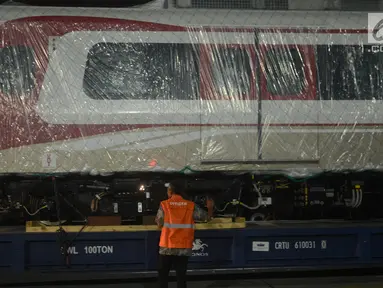 Pekerja mengecek gerbong kereta ringan/Light Rail Transit (LRT) yang baru tiba di Pelabuhan Car Terminal, Tanjung Priok, Jakarta, Jumat (13/4).  Dua gerbong kereta LRT yang diangkut itu merupakan yang pertama tiba di Jakarta. (Merdeka.com/Imam Buhori)