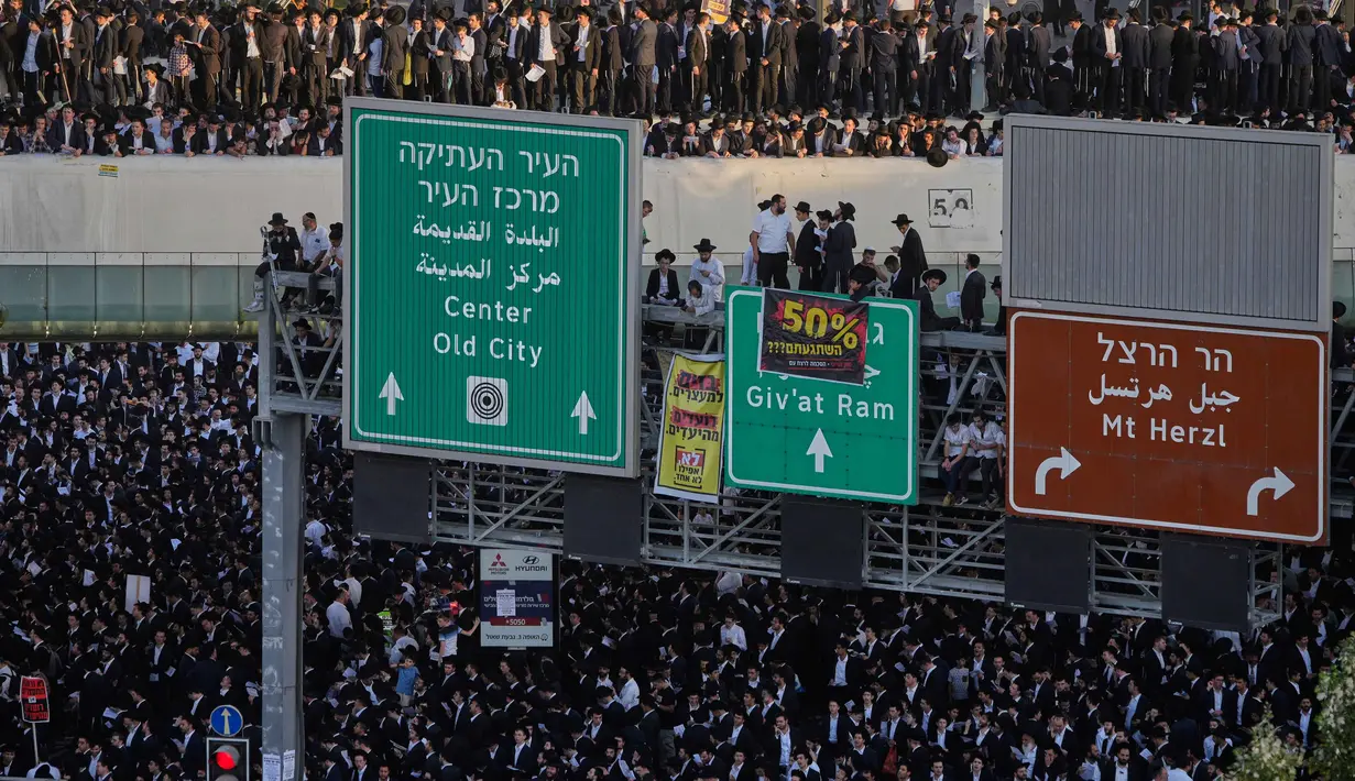 Pria Yahudi Ultra-Ortodoks memprotes rencana pemaksaan mereka untuk bertugas di militer Israel, di Yerusalem, Kamis 30 Oktober 2025. Para pria ultra-Ortodoks tersebut bernyanyi, bertepuk tangan, dan membawa spanduk bertuliskan bahwa mereka lebih memilih masuk penjara daripada harus masuk militer. (AP Photo/Ohad Zwigenberg)
