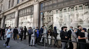 Orang-orang antre di luar toko Niketown di London, Senin (15/6/2020). Antrean panjang terjadi di luar toko-toko yang berada di sejumlah kota di Inggris saat negara itu melakukan pelonggaran lockdown dan mulai membuka pusat perbelanjaan. (AP/Matt Dunham)