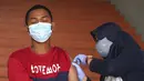 Warga menerima suntikan vaksin virus corona COVID-19 Sinovac di Stadion Patriot Candrabhaga, Bekasi, Kamis (28/10/2021). Indonesia melihat ke depan dengan waspada akan gelombang ketiga COVID-19 selama perjalanan liburan yang akan datang. (AP Photo/Achmad Ibrahim)