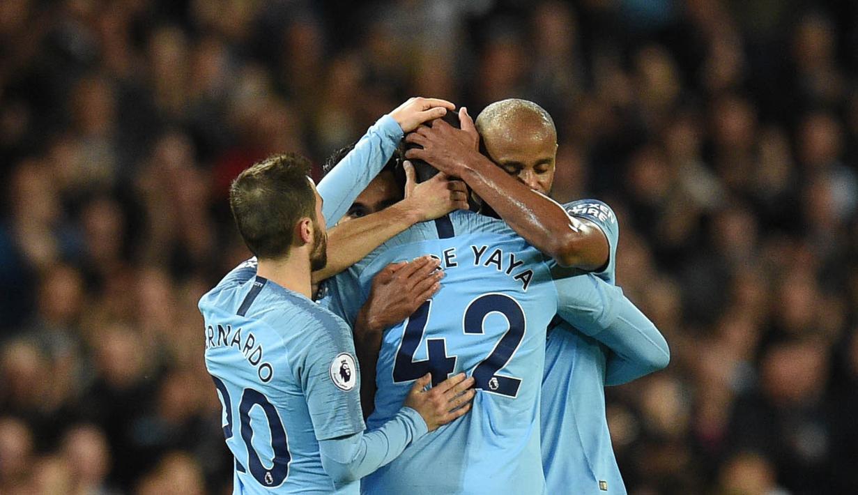 Para pemain Manchester City memeluk Yaya Toure usai laga melawan Brighton and Hove Albion di Stadion Etihad, Rabu (9/5/2018). Laga tersebut menjadi ajang perpisahan sang pemain bersama The Citizens. (AFP/Oli Scarff)