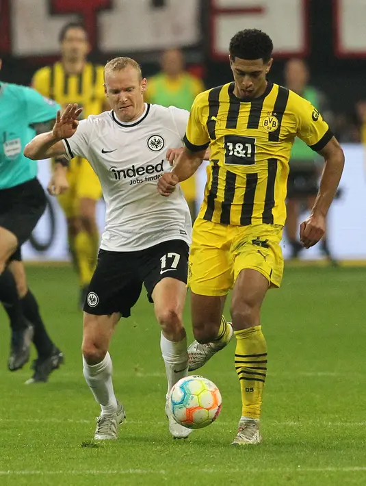 Gelandang Borussia Dortmund, Jude Bellingham (kanan) dan gelandang Eintracht Frankfurt, Sebastian Rode berebut bola pada laga pekan ke-12 Bundesliga Jerman 2022/2023 di Deutsche Bank Park, Minggu (30/10/2022) dini hari WIB. Borussia Dortmund menang tipis 3-2 atas tuan rumah Eintracht Frankfurt. (Photo by Daniel ROLAND / AFP)