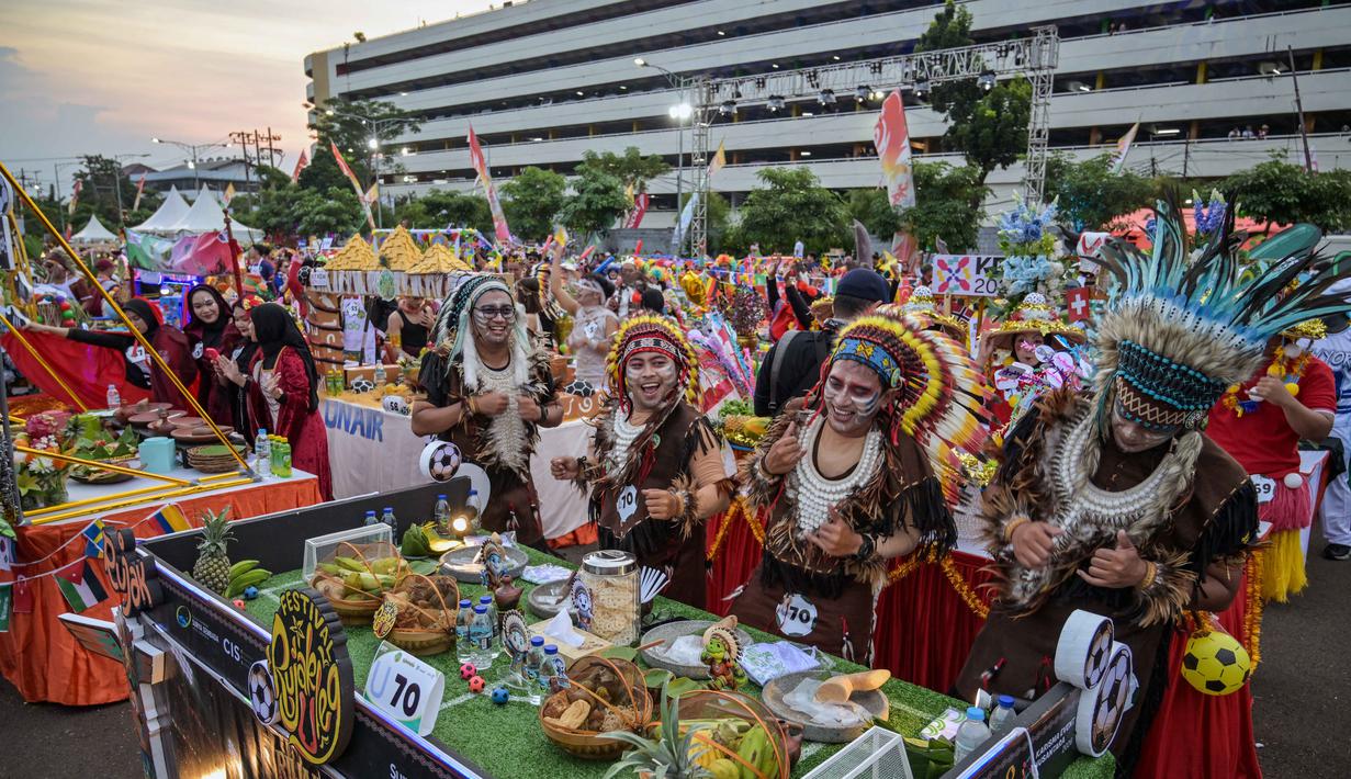 Festival Rujak Uleg 2026 menjadi pesta rakyat sekaligus magnet wisata yang menarik ribuan pengunjung dari berbagai daerah. Tampak dalam foto, Para peserta yang mengenakan pakaian tradisional penduduk asli Amerika menari sebelum menyiapkan rujak uleg, salad gurih tradisional Indonesia yang berisi moncong sapi dan sayuran, dalam Festival Rujak Uleg 2026 di Surabaya, Jawa Timur, Sabtu 9 Mei 2026. (JUNI KRISWANTO/AFP)