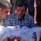 Sang ayah Abdullah Kurdi memakamkan putra tercintanya Aylan Kurdi di Suriah. (BBC)