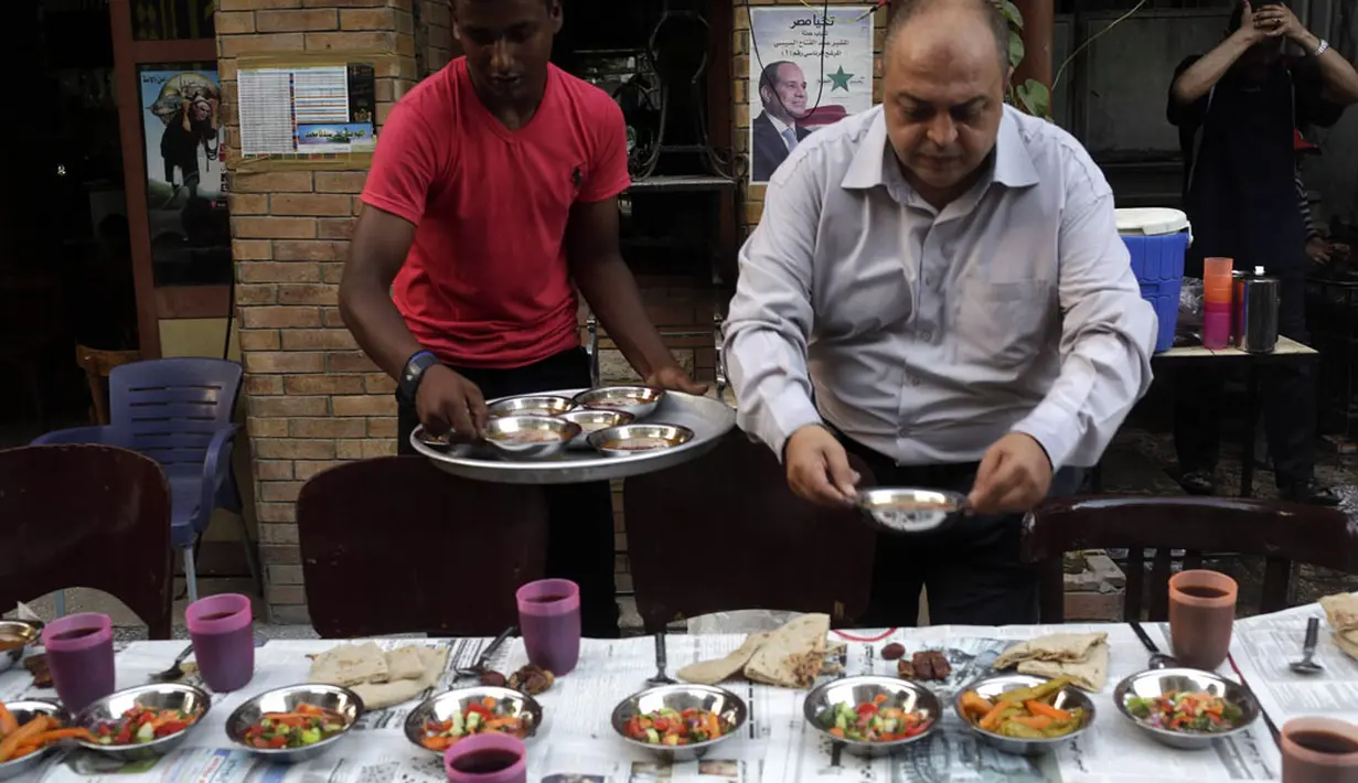 Di Kairo, (29/6/2014), beberapa pria terlihat menjadi relawan yang menyiapkan dan mendistribusikan makanan untuk berbuka puasa. (REUTERS/Asmaa Waguih) 
