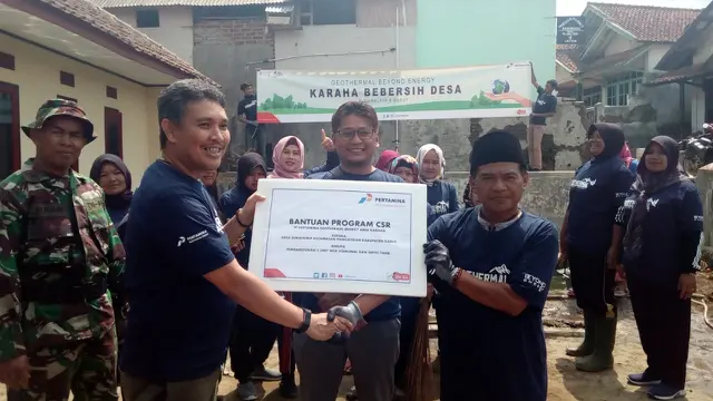 Rawan Mirza, Pjs. Area Manager Karaha tengah memberikan duplikat bantua MCK bagi Kepala Desa Sukahurip Supiat dalam kegiatan Beberesih Desa, Jumat (22/11/2019)