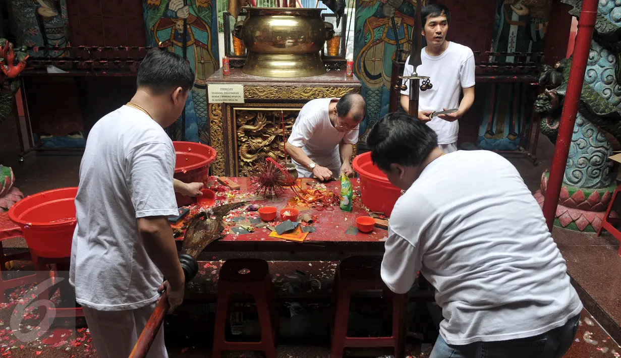 Umat Tionghoa mencuci dan membersihkan sejumlah alat pusaka seperti Pedang dan Golok saat prosesi pensucian tandu (kio) yang digunakan  mengusung arca suci saat perayaan cap go meh, di Vihara Bodhi Dharma, Jakarta, (20/2). (Liputan6.com/Johan Tallo)