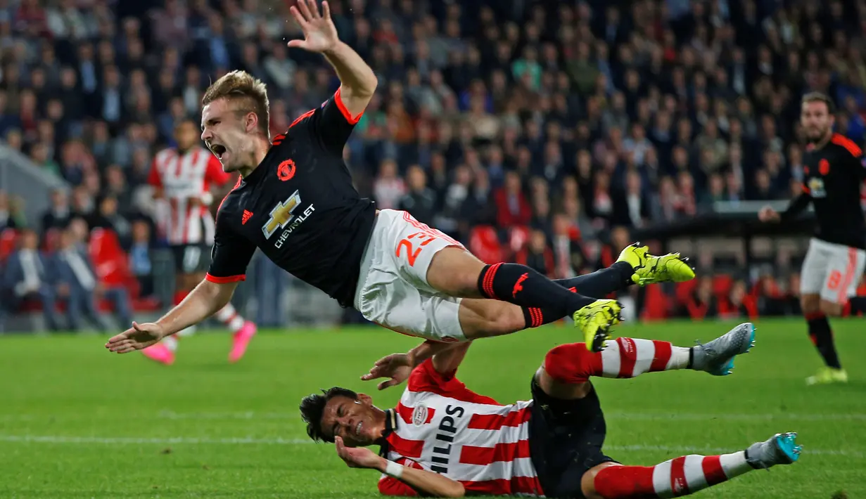 Pemain Manchester United, Luke Shaw, dijatuhkan pemain PSV, Hector Moreno dalam pertandingan Grup B Liga Champions yang berlangsung di Stadion Philips, Eindhoven, Belanda. Selasa (12/9/2015). (Action Images via Reuters /Andrew Couldridge)