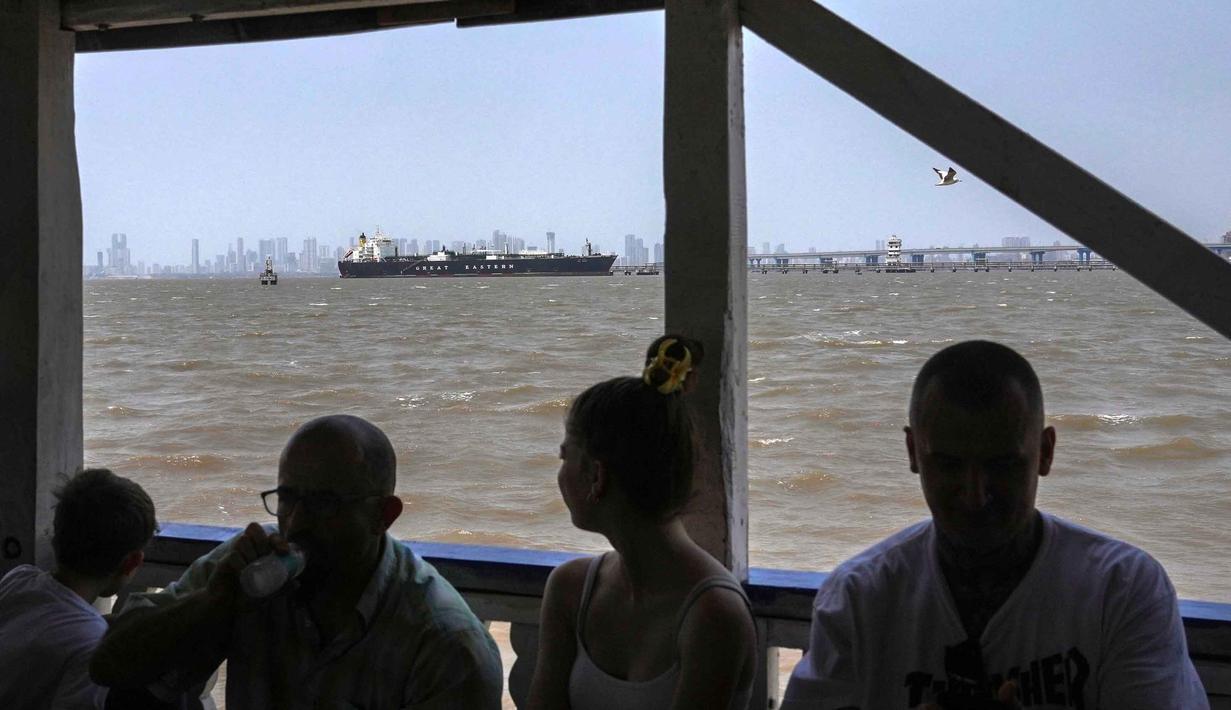 Sebagai informasi, Selat Hormuz merupakan jalur laut sempit dan strategis yang terletak di antara Iran (utara) dan Oman/Uni Emirat Arab (selatan). Tampak dalam foto, sebuah feri wisata berlayar melewati kapal pengangkut Liquefied Petroleum Gas (LPG) berbendera India, Jag Vasant, yang mengangkut gas minyak cair, di Pelabuhan Mumbai, India, setelah tiba melewati Selat Hormuz, Rabu, 1 April 2026. (AP Photo/Rafiq Maqbool)