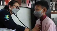 Dokter memeriksa kesehatan anak Sekolah Dasar Negeri 06 Lubang Buaya, Jakarta, Jumat (25/8/2023). Pemeriksaan dilakukan untuk menskrining kemungkinan anak-anak terjangkit Infeksi Saluran Pernapasan Akut (ISPA). (merdeka.com/Imam Buhori)
