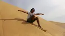 Ekspresi sorang pria saat menikmati berseluncur di gurun pasir Wadi el-Rayan Fayoum, Mesir (18/11). Di gurun ini menyajikan banyak hiburan dan pariwisata salah satunya, berseluncur di pasir atau sandboarding. (Reuters/Mohamed Abd El Ghany)