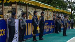 Sejumlah perwira polisi berjaga dekat narkotika sitaan sebelum acara pemusnahan pada Hari Antinarkoba Sedunia, di Yangon, Senin (26/6). Myanmar membakar opium, heroin, dan kokain senilai sekitar US$385 juta, setara Rp5,1 miliar. (AP Photo/Thein Zaw)