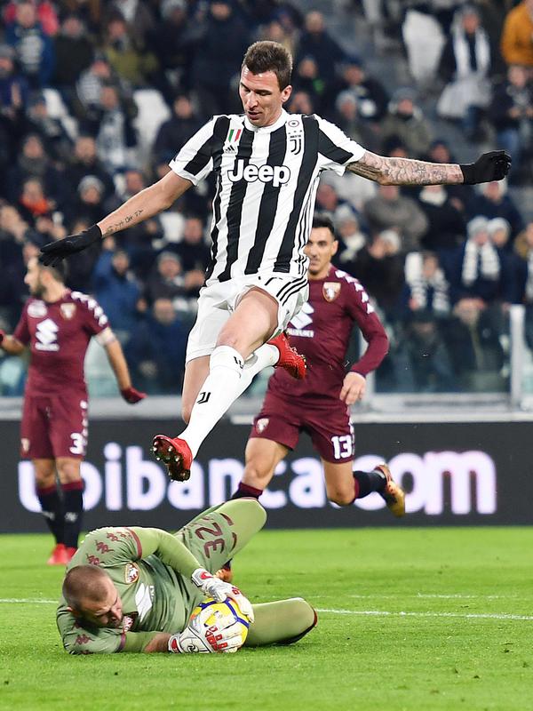 Pemain Juventus, Mario Mandzukic melompati kiper Torino, Vanja Milinkovic-Savic dalam lanjutan Coppa Italia di Stadion Allianz, Rabu (3/1). Mandzukic menyumbang satu dari dua gol untuk Juventus melenggang ke babak semifinal. (Andrea Di Marco/ANSA via AP)