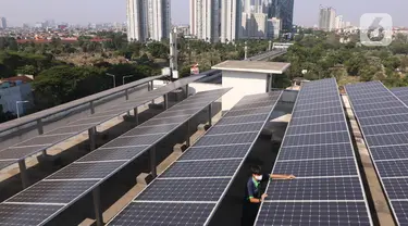 Pekerja melakukan pengecekan panel surya di atas gedung di kawasan Jakarta, Senin (31/8/2020). Pemerintah tengah menyiapkan peraturan presiden terkait energi baru terbarukan dan konservasi energi agar target 23 persen bauran energi di Indonesia bisa tercapai pada 2045. (Liputan6.com/Angga Yuniar)