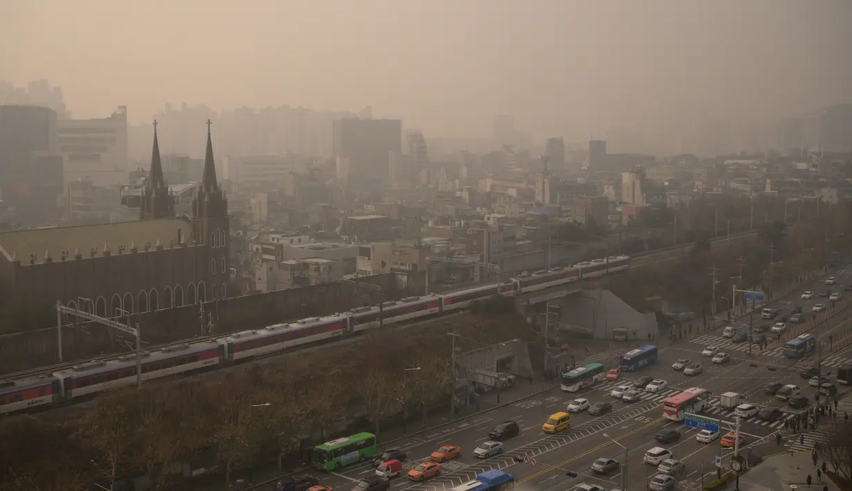 Sejumlah kendaraan melintas selama kondisi cuaca yang sangat tercemar di Seoul (10/12/2019). Menurut World Quality Quality Index, kadar partikel ultra-halus mencapai 194 di Korea Selatan. (AFP Photo/Ed Jones)