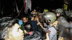 Massa aksi terlibat bentrok dengan polisi yang berjaga saat menggelar aksi unjuk rasa di depan Istana Negara, Kamis (12/1). Dalam aksinya mereka menuntut Presiden Jokowi-JK untuk membuat kebijakan yang pro terhadap rakyat. (Liputan6.com/Faizal Fanani)