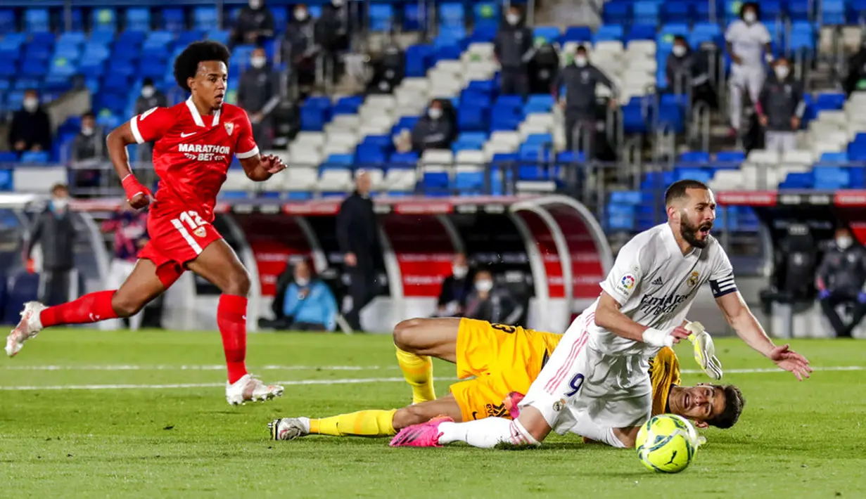 Pemain Real Madrid Karim Benzema (depan) berebut bola dengan penjaga gawang Sevilla Bono pada pertandingan La Liga Spanyol di Alfredo di Stefano Stadium, Madrid, Spanyol, Minggu (9/5/2021). (AP Photo/Manu Fernandez)