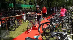 Selebriti Widi Mulia saat mengikuti kompetisi sepeda pada ajang Jakarta Kids Triathlon di Deutsche Schule Jakarta, Tangsel, Minggu (25/09). Kompetisi tersebut dilakukan secara berkesinambungan dalam satu kesatuan waktu. (Liputan6.com/Fery Pradolo)