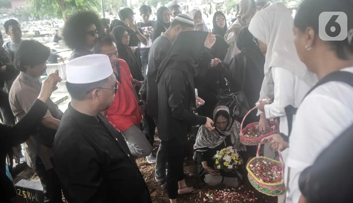 Keluarga menaburkan bunga di atas pusara mantan artis cilik Cecep Reza saat pemakaman di TPU Layur Penggilingan, Jakarta, Rabu (20/11/2019). Cecep Reza meninggal pada usia 31 tahun karena penyakit jantung. (Liputan6.com/Faizal Fanani)
