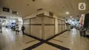 Pengunjung berada di dekat toko ritel yang tutup di salah satu pusat perbelanjaan kawasan Glodok, Jakarta, Senin (7/6/2021). Data Aprindo mencatat, sepanjang Maret 2020 hingga April 2021 sebanyak 1.250-1.300 toko ritel di Indonesia terpaksa tutup. (merdeka.com/Iqbal S. Nugroho)