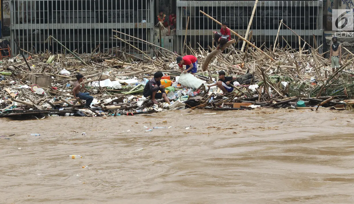 Pemulung bersama sejumlah anak mencari botol-botol plastik yang tersangkut diantara tumpukan sampah di Pintu Air Manggarai, Jakarta, Jumat (26/4). Sampah ini terbawa arus sungai Ciliwung akibat curah hujan yang tinggi di kawasan Bogor dan sekitarnya, Kamis (25/4). (Liputan6.com/Helmi Fithriansyah)