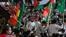 Para tahanan bersorak di antara para pendukungnya setelah dibebaskan dari penjara Israel di Ramallah, Tepi Barat yang diduduki, pada tanggal 26 November 2023. (Jaafar ASHTIYEH/AFP)