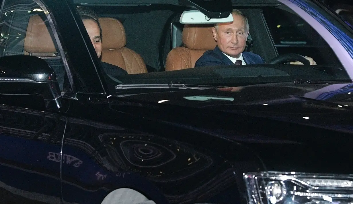 Presiden Rusia Vladimir Putin (kanan) mengendarai limosin Aurus saat menemani Presiden Mesir Abdel Fattah el-Sisi (kiri) melihat sirkuit F1 Sochi, Rusia, Rabu (17/10). Mesir menandatangani kesepakatan strategis dengan Rusia. (Alexei Druzhinin/Sputnik/AFP)