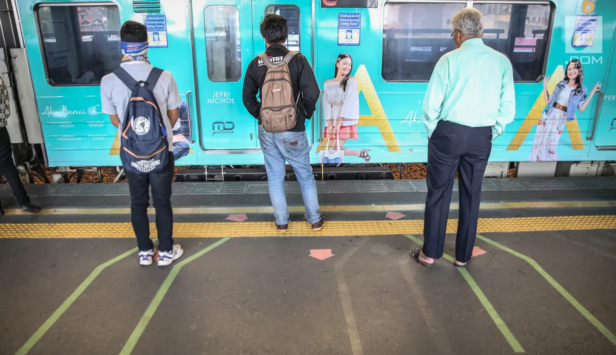 Penumpang berdiri di garis antrean penumpang di Stasiun Juanda, Jakarta, Kamis (10/8). Uji coba garis antrean penumpang juga guna mengurangi bahaya kecelakaan seperti penumpang terjatuh dan terdorong saat keluar masuk KRL. (Liputan6.com/Faizal Fanani)