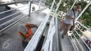 Pekerja mengecat jembatan penyeberangan menuju halte Transjakarta di kawasan Cawang, Jakarta, Rabu (5/4). Pengecatan dilakukan untuk menjaga halte agar tetap bersih dan terawat. (Liputan6.com/Immanuel Antonius)