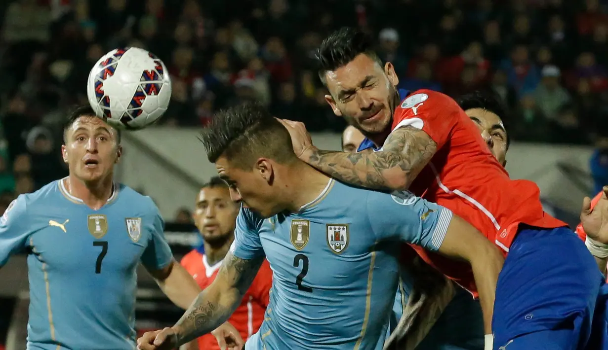 Duel antara pemain Uruguay, Jose Maria Gimenez (kiri), dan Mauricio Pinilla. (AP Photo/Luis Hidalgo)