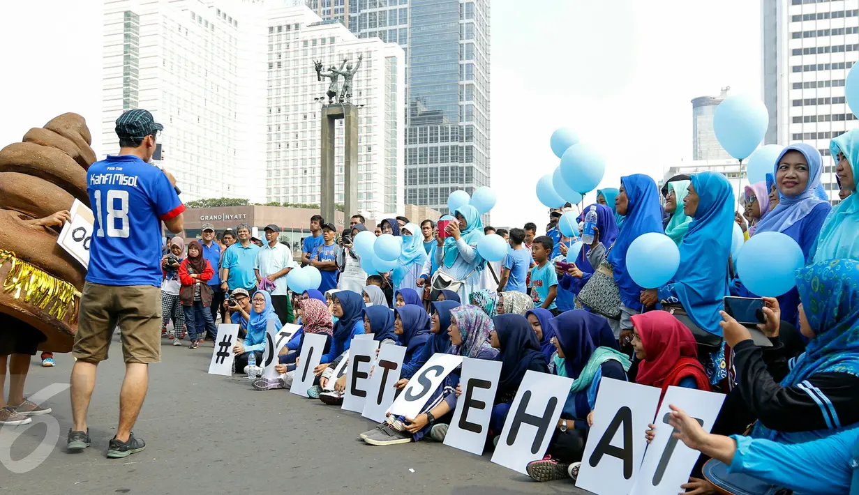 Puluhan warga sosialisasikan 'Toilet Sehat' saat Car Free Day (CFD) di Bundaran HI, Jakarta, Minggu (15/11/2015). Dalam acara tersebut tampil sebuah maskot berbentuk kotoran manusia yang membuat suasana semakin seru. (Liputan6.com/Yoppy Renato)