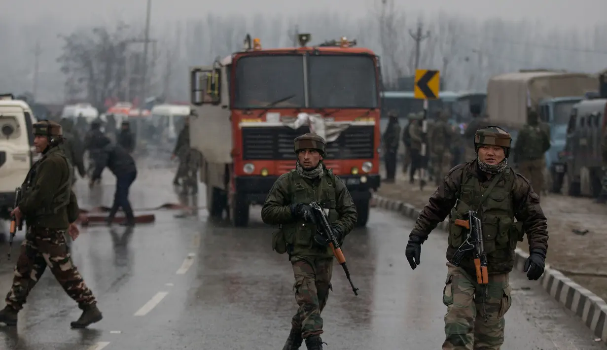 Tentara India berpatroli di dekat lokasi ledakan bom mobil di Lethpora di distrik Pulwama, Kashmir, India (14/2). Menurut kesaksian dari seorang perwira polisi mobil bermuatan bom tersebut meledak usai menabrak konvoi pasukan CRPF. (AP Photo/Dar Yasin)
