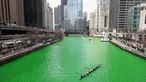 Sejumlah orang berkerjasama mendayung perahu sesaat setelah Sungai Chicago berubah hijau di Illinois, AS, Sabtu (17/3). Pembuatan warna air sungai menjadi hijau itu dilakukan sebagai bagian dari perayaan tahunan St. Patrick's Day. (Olson/Getty Images/AFP)