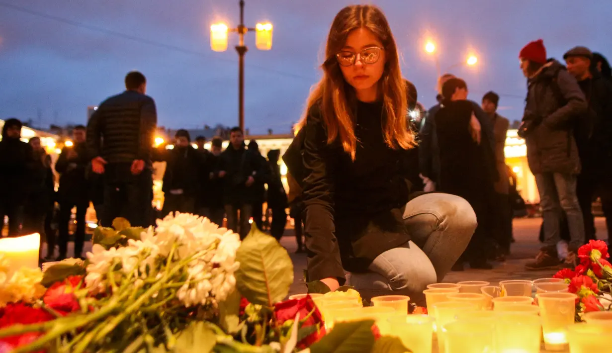 Warga meletakan  karangan bunga di dekat lokasi ledakan bom di stasiun kereta bawah tanah St. Petersburg, Senin (3/4). Sampai saat ini penyebab ledakan masih samar. Belum ada kelompok yang mengklaim ledakan ini. (AP Photo / Dmitri Lovetsky)