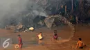 Beberapa warga berusaha menyiramkan air sungai saat terjadinya kebakaran yang melanda rumah hunian semi permanen di bantaran sungai anak kali ciliwung, Kawasan Kampung Berland, Jakarta, Rabu (2/9/2015). (Liputan6.com/Johan Tallo)