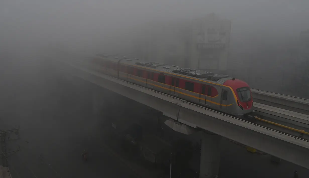 Kereta Metro Jalur Oranye (OLMT) melaju di tengah cuaca berkabut di Lahore (21/12/2022). Kabut tebal kembali menyelimuti berbagai kota di Punjab, termasuk Lahore pada malam hari antara Selasa dan Rabu, melumpuhkan kehidupan sehari-hari dan mengganggu lalu lintas jalan raya dan udara.(AFP/Arif Ali)