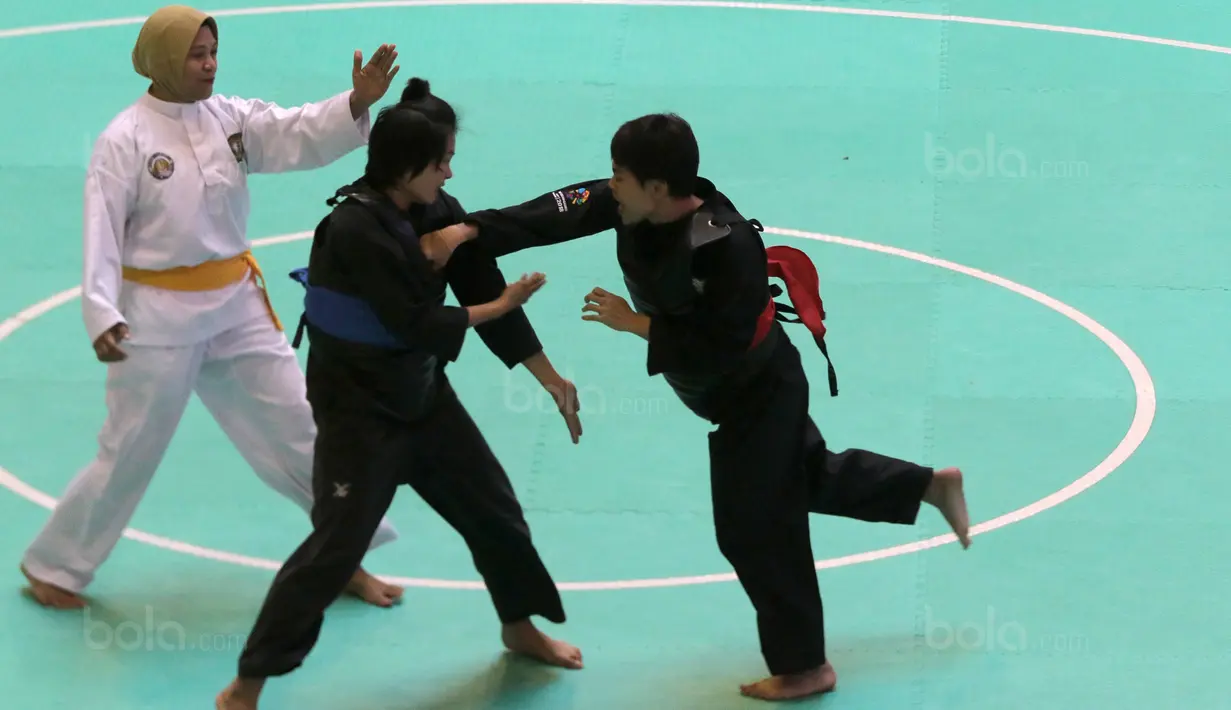 Pesilat Indonesia, Octaviani Nirmalasari (kanan) melepaskan pukulan kearah pesilat Laos, Olahthai Sounthavong pada semifinal Test Event Pencak Silat 2018 di Padepokan Silat TMII, Jakarta, (12/2/2018). Oktaviani menang 5-0. (Bola.com/Nick Hanoatubun)