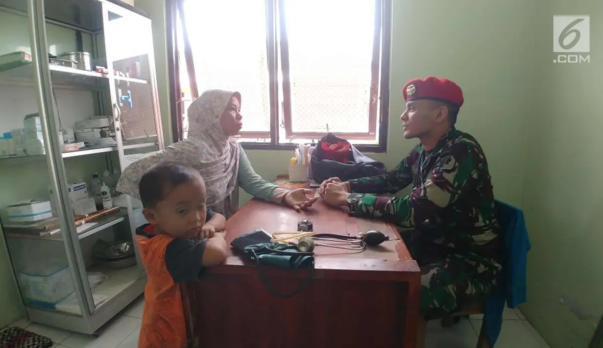 Seorang prajurit Kopassus berbincang saat memeriksa kondisi salah satu warga terdampak gempa yang mengguncang sejumlah wilayah Jawa Barat dan Banten di Desa Citalahap, Kabupaten Lebak, Bogor (23/1). (LIputan6.com/Pool/Kopassus)