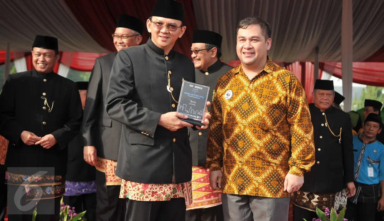 Gubernur DKI Basuki Tjahaja menerima penghargaan gelar sebagai National Earth Hour Capital dalam ajang Earth Hour City Challenge (EHCC) tahun 2016, usai upacara peringatan HUT Jakarta ke-489 di Lapangan Monas, Rabu (22/6). (Liputan6.com/Gempur M Surya)