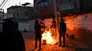 Pria pengangguran membakar kardus saat fajar di Gaza, (18/2). Pria itu mengatakan akan dengan senang hati bekerja hanya dengan 5 syikal sehari tetapi tidak ada pekerjaan. Oktober 2018, Bank Dunia mengatakan, 54 persen tenaga kerja Gaza menganggur, termasuk 70 persen pemuda. (Reuters/Dylan Martinez)