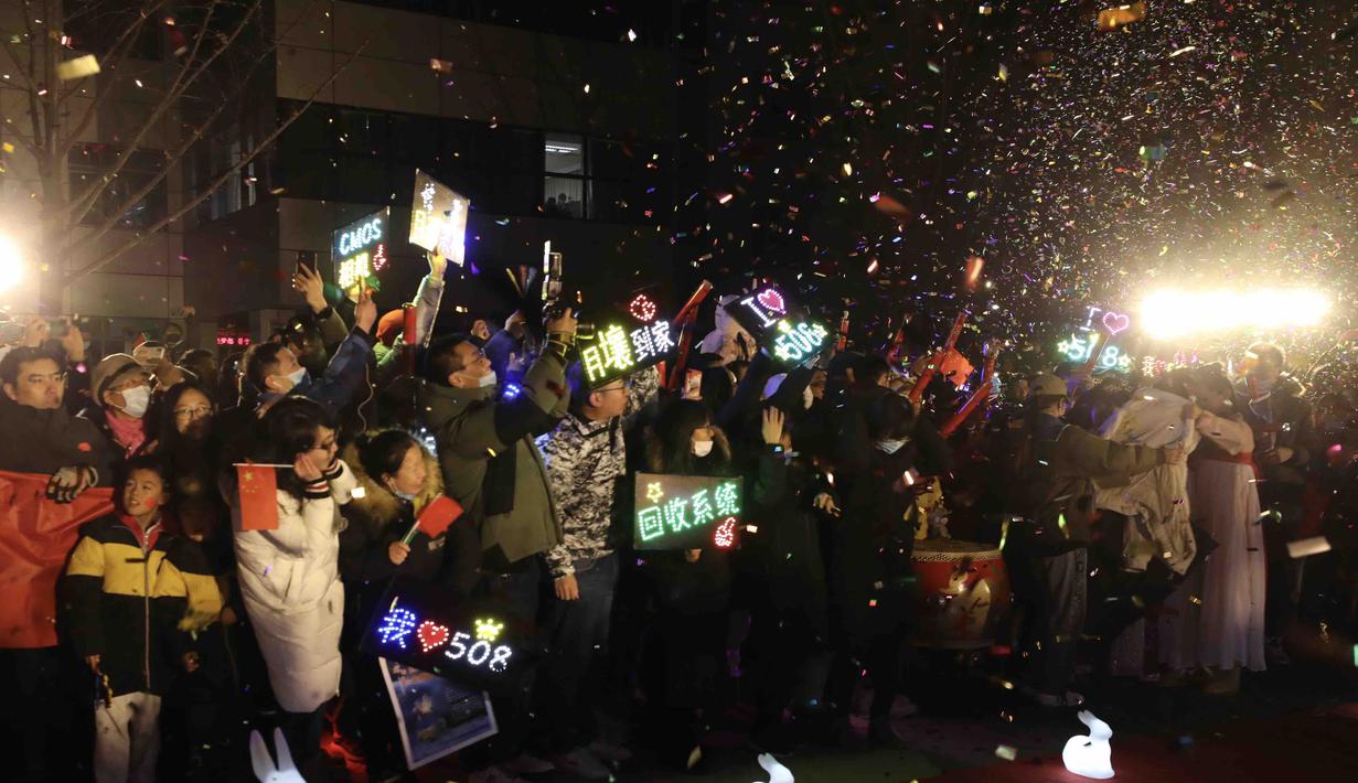 Orang-orang merayakan kedatangan kapsul pembawa pulang (return capsule) wahana antariksa China, Chang'e-5, di Akademi Teknologi Luar Angkasa China di Beijing, China (17/12/2020). (Xinhua/Jin Liwang)